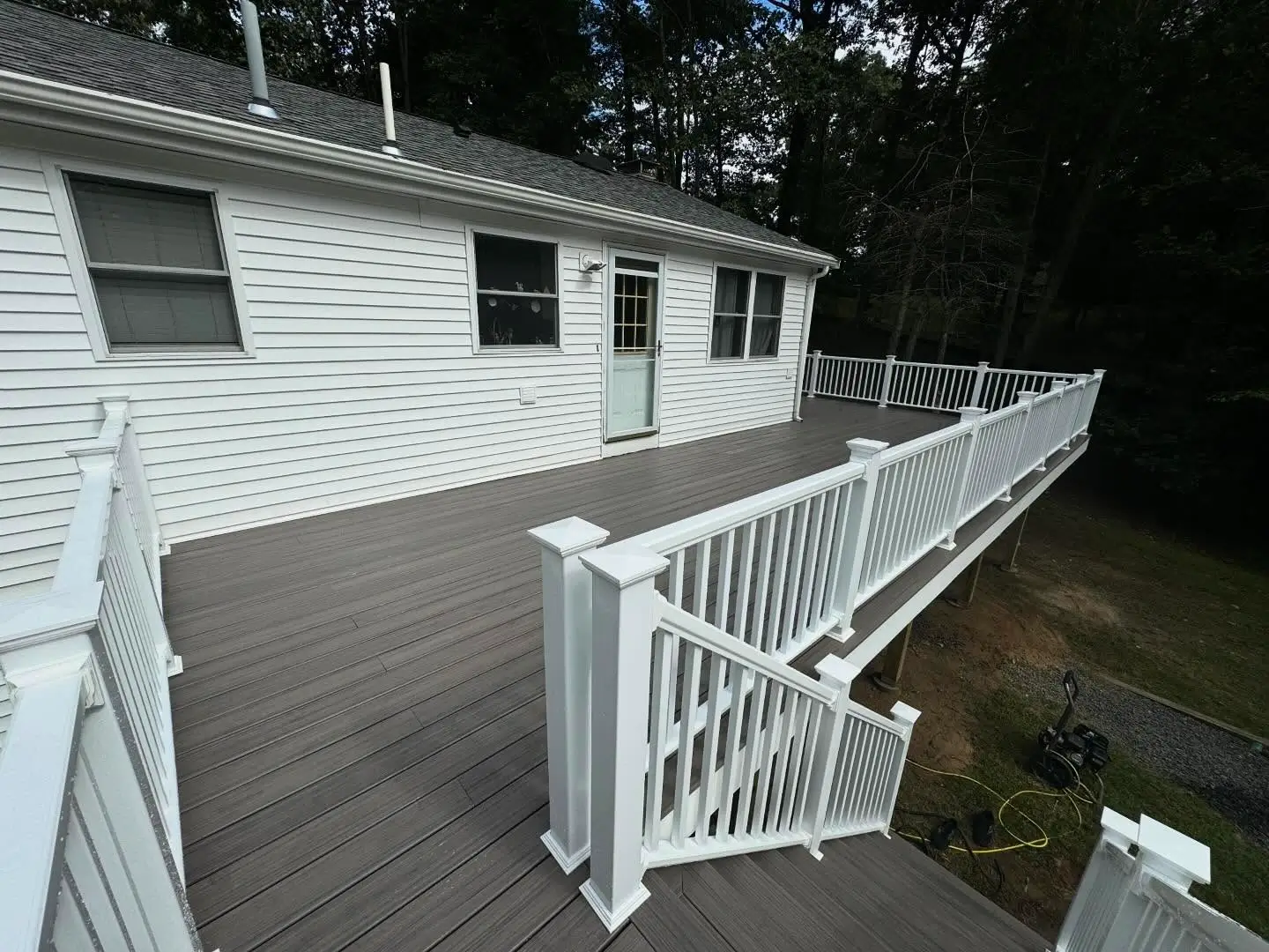 Spacious composite wrap-around deck with white vinyl railing.