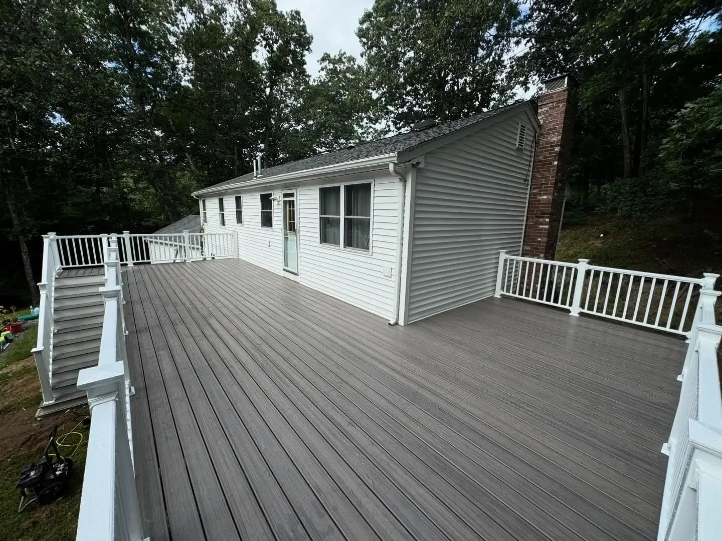 Custom composite deck with white vinyl posts and dark grey decking boards.