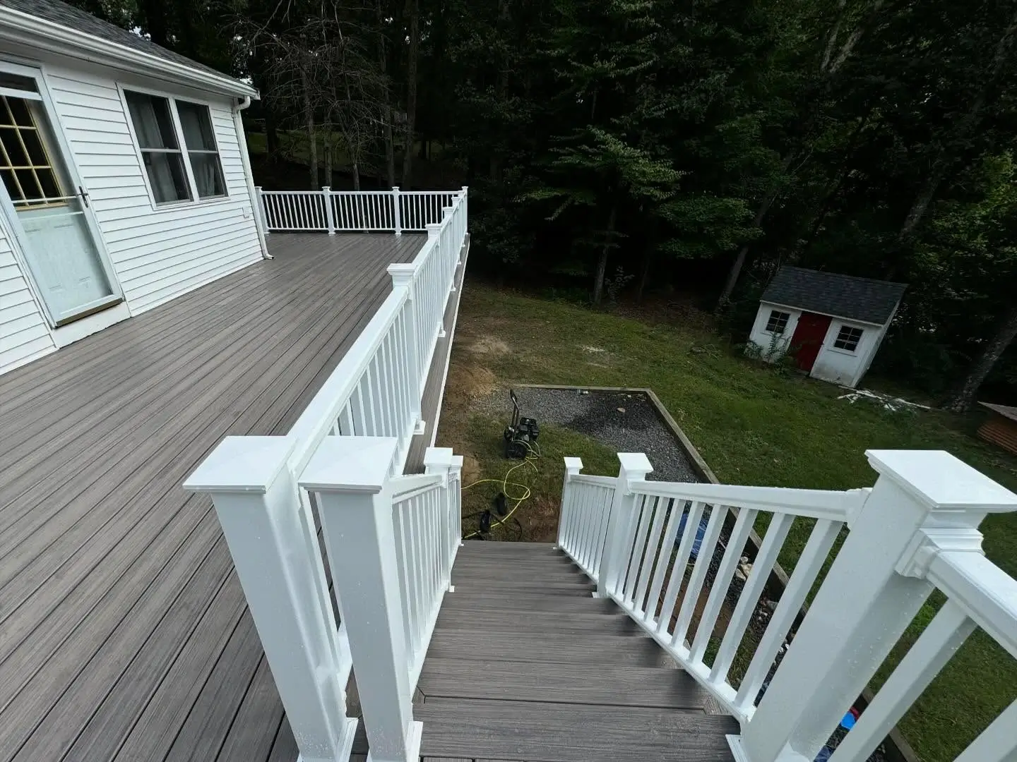 Sturdy composite stairs leading down from an elevated back deck.
