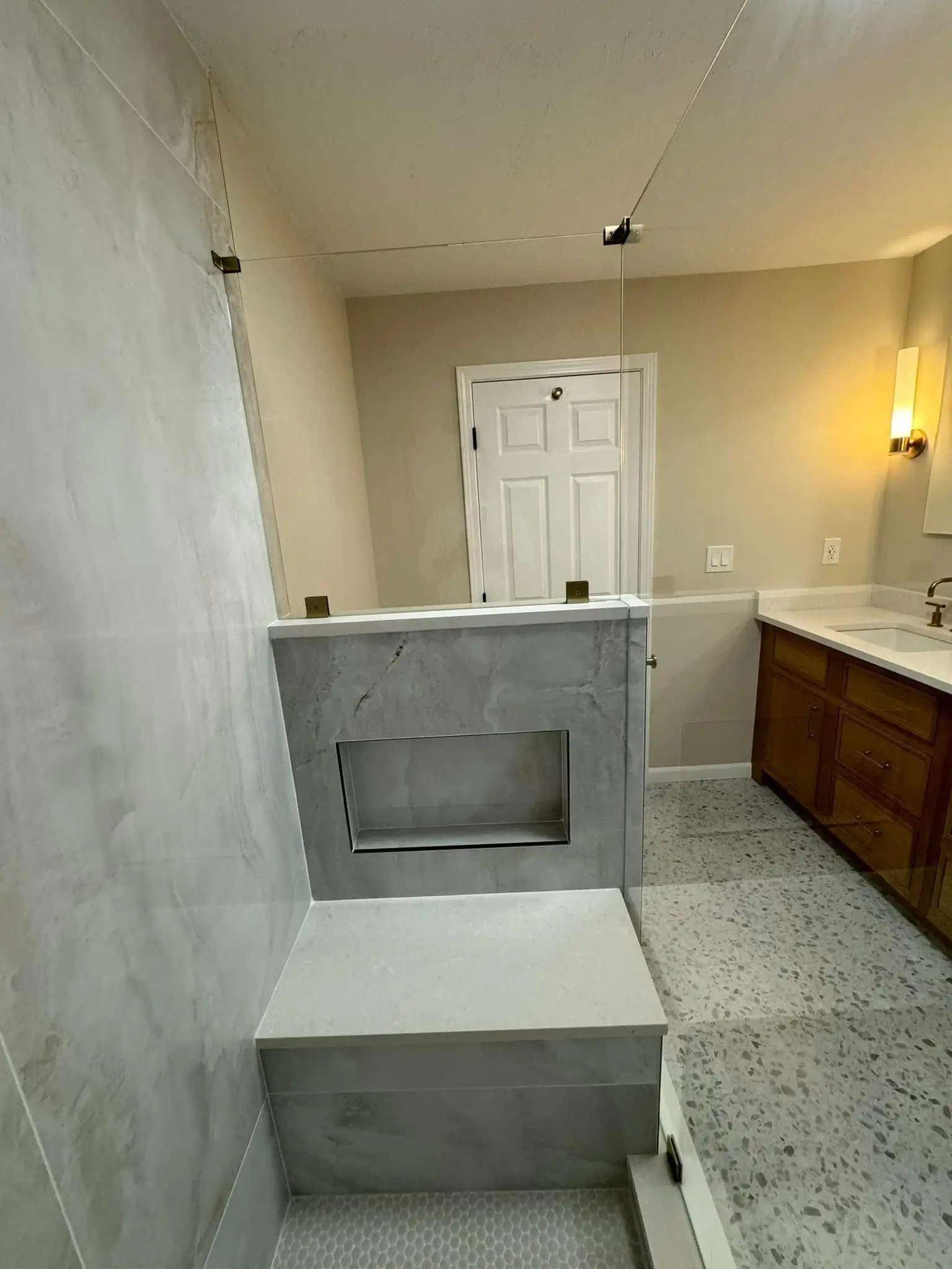 Tiled walk-in shower with a built-in tile bench and shower niche.