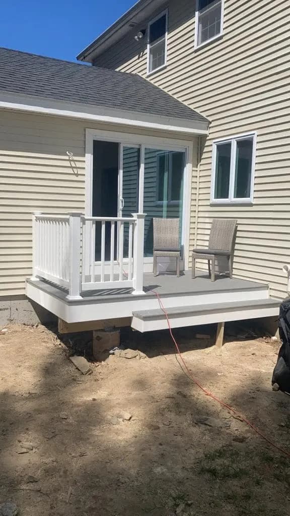 Composite landing deck and stairs at the side entrance of a home.