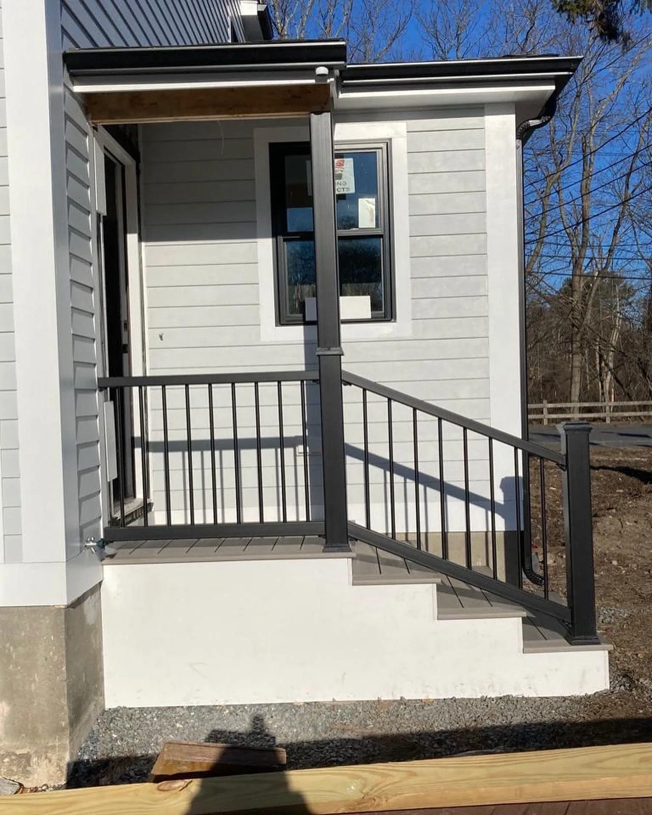 Small composite entry landing with black metal railings.