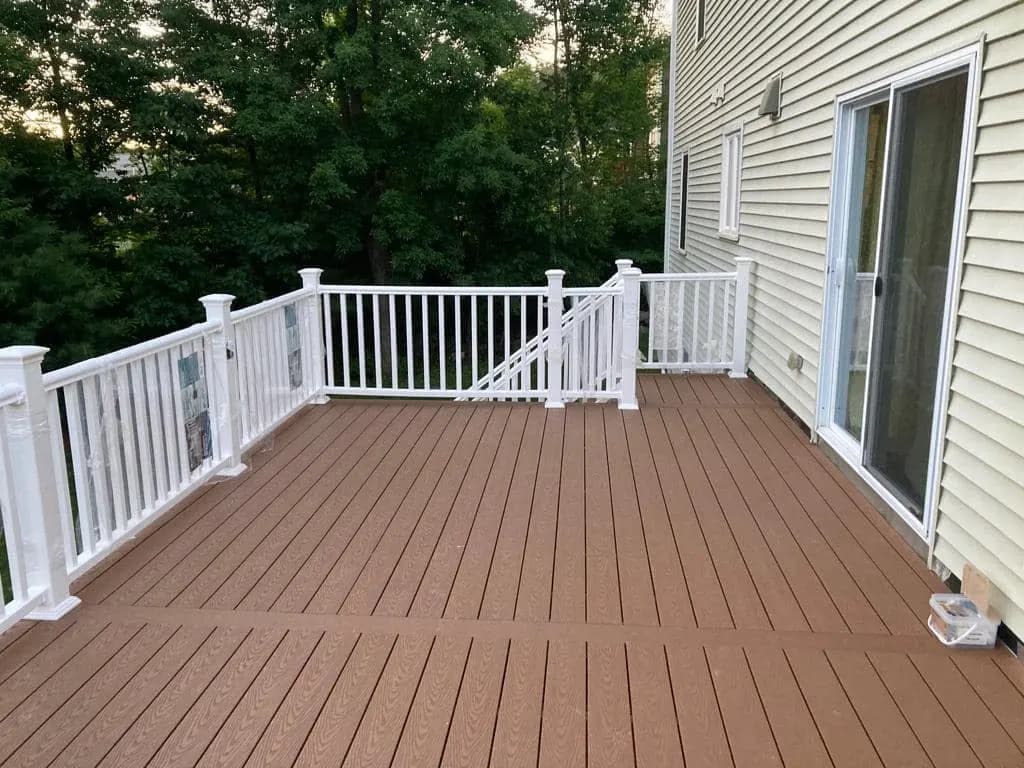 Clean view of new low-maintenance composite deck boards and white posts.