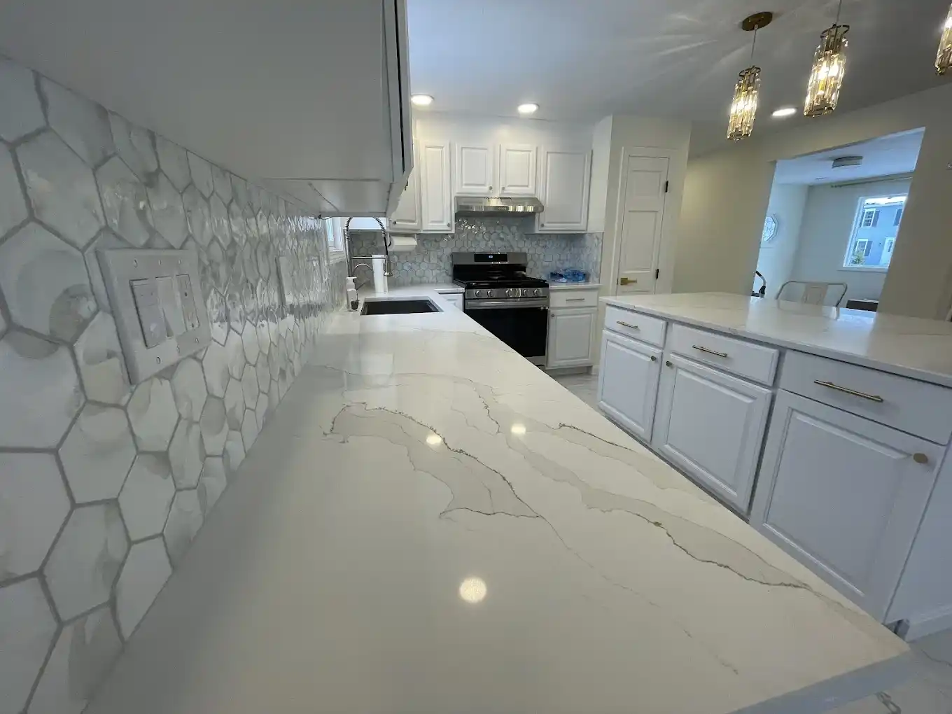Kitchen remodel detailing an apron-front farmhouse sink and quartz counter.