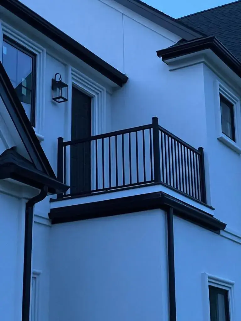 Elevated composite deck with modern black railings and post caps.