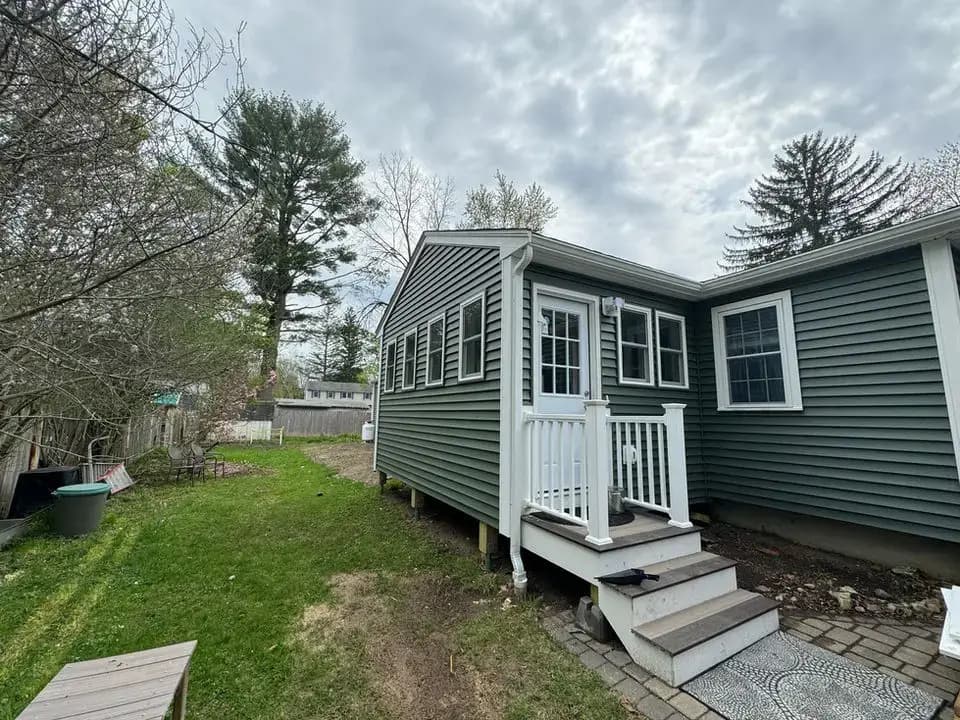Custom composite side entryway deck and stairs with white vinyl railings.